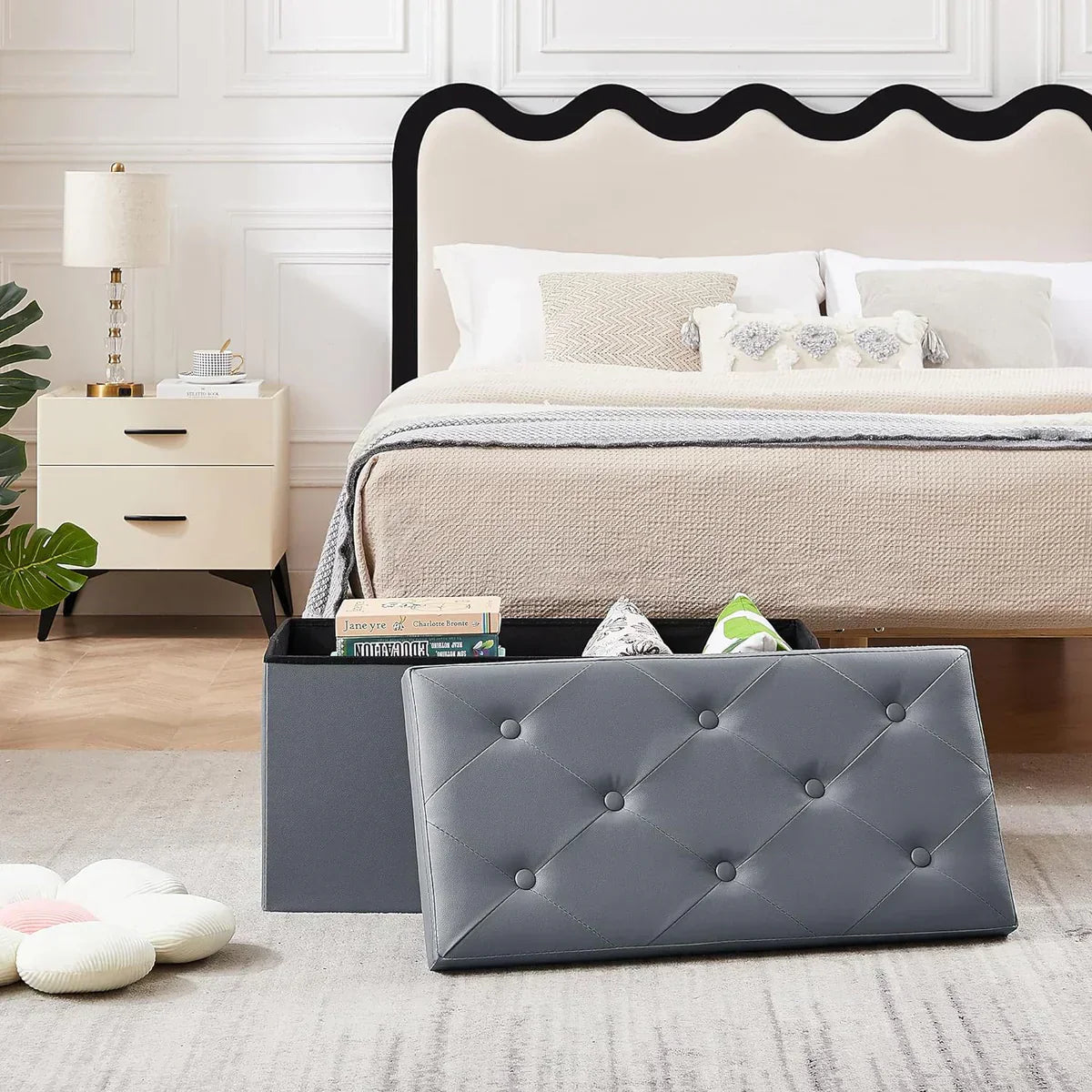 VECELO grey tufted storage ottoman bench in a cozy small bedroom setting, serving as both seating and hidden storage for books and accessories.